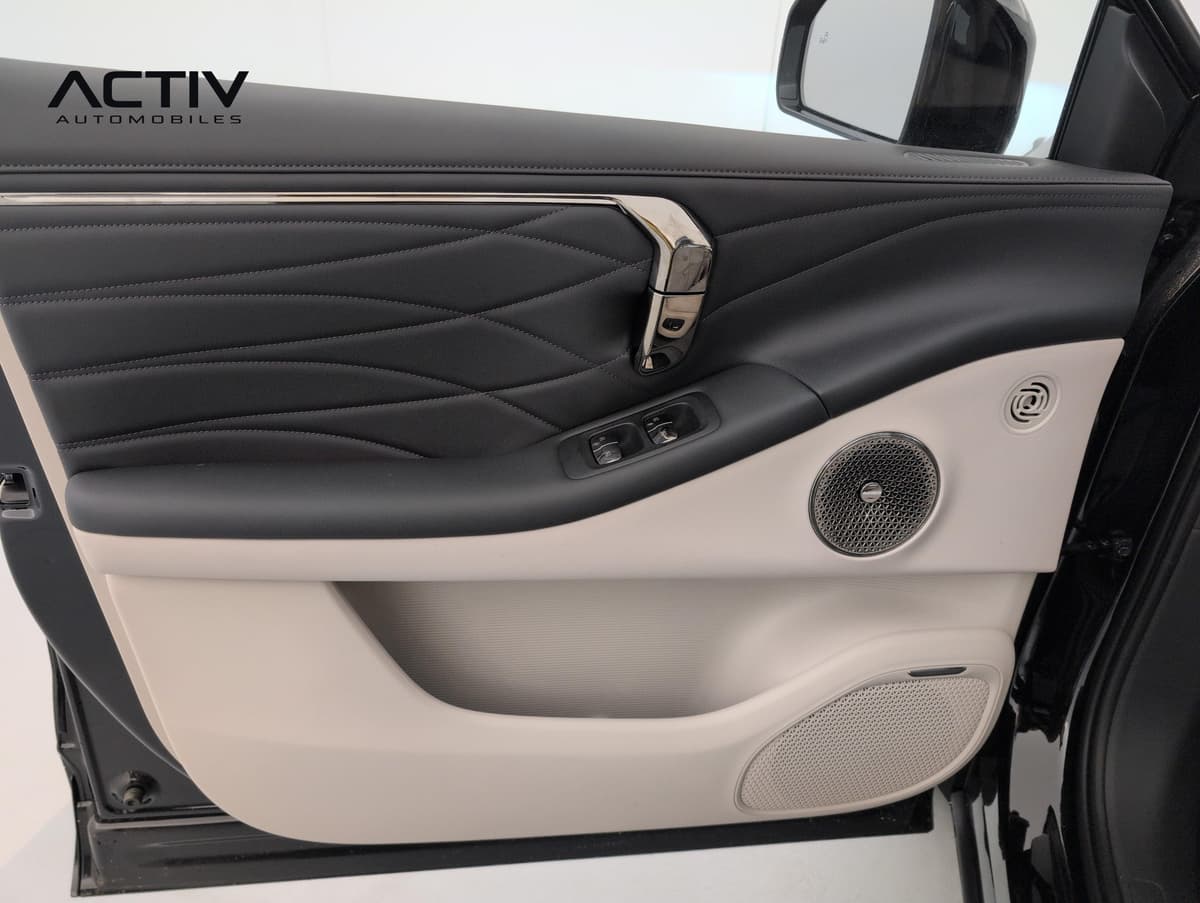 Aion V : panneau de porte avant bicolore noir et beige avec commandes de vitres et haut-parleurs