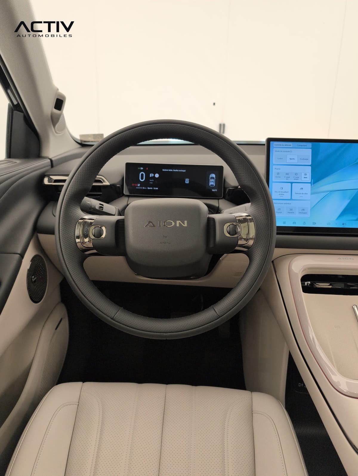 Aion V : volant avec commandes et combiné numérique devant le siège conducteur beige