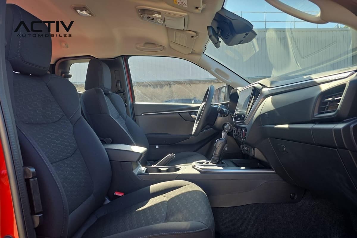 Isuzu D-MAX : habitacle avant côté passager avec sièges en tissu noir et levier de vitesses
