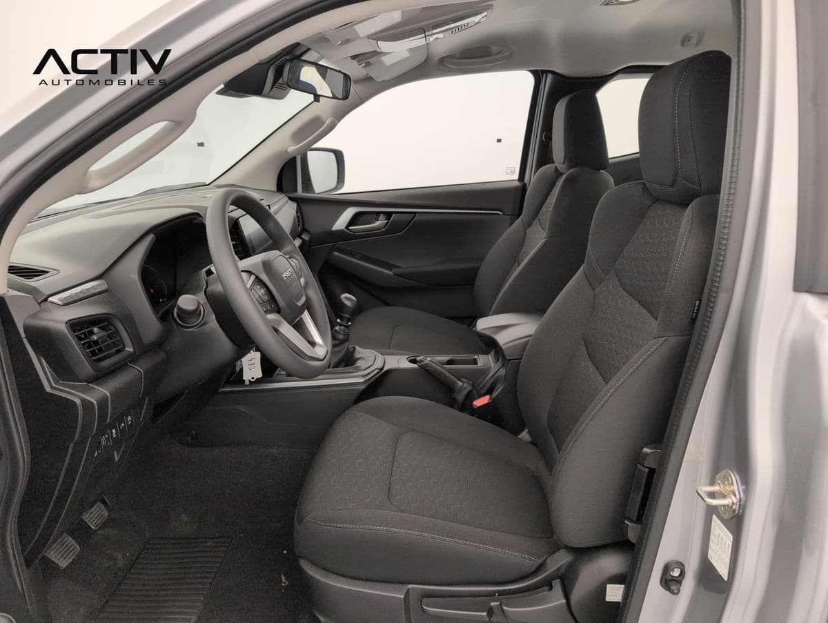 Isuzu D-MAX : habitacle avant vu côté passager, sièges en tissu noir et levier de vitesses manuel