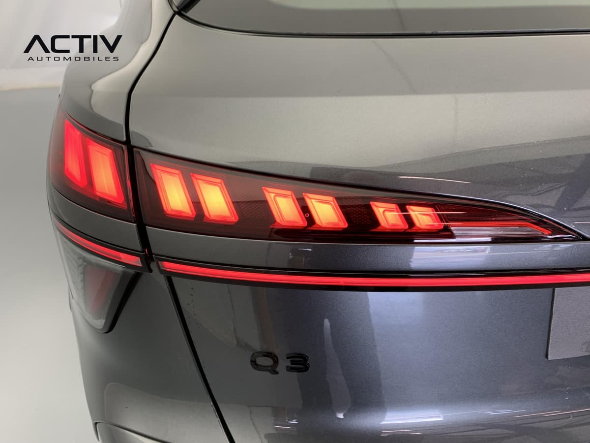 Audi Q3 Sportback Hybride : feu arrière à LED allumé avec bande lumineuse rouge et monogramme noir