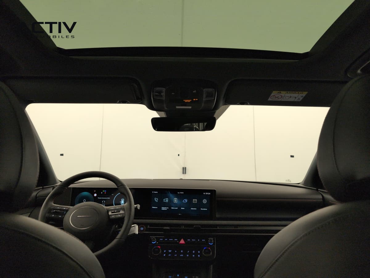 Hyundai Tucson : habitacle vu depuis l'arrière avec toit vitré, planche de bord et écrans