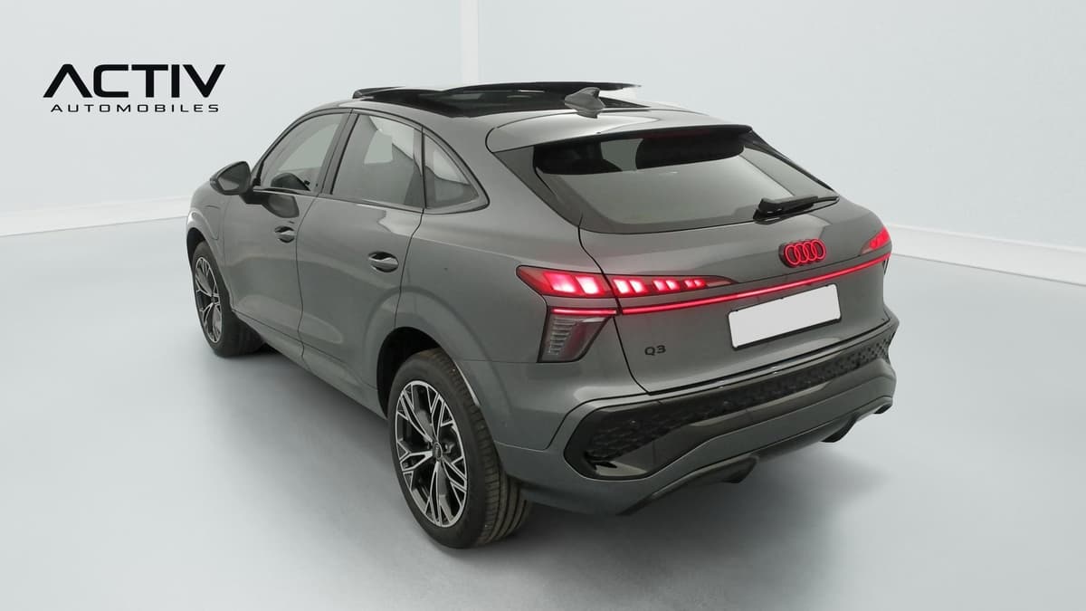Audi Q3 Sportback Hybride : arrière trois quarts gauche avec feux à LED allumés et jantes bicolores