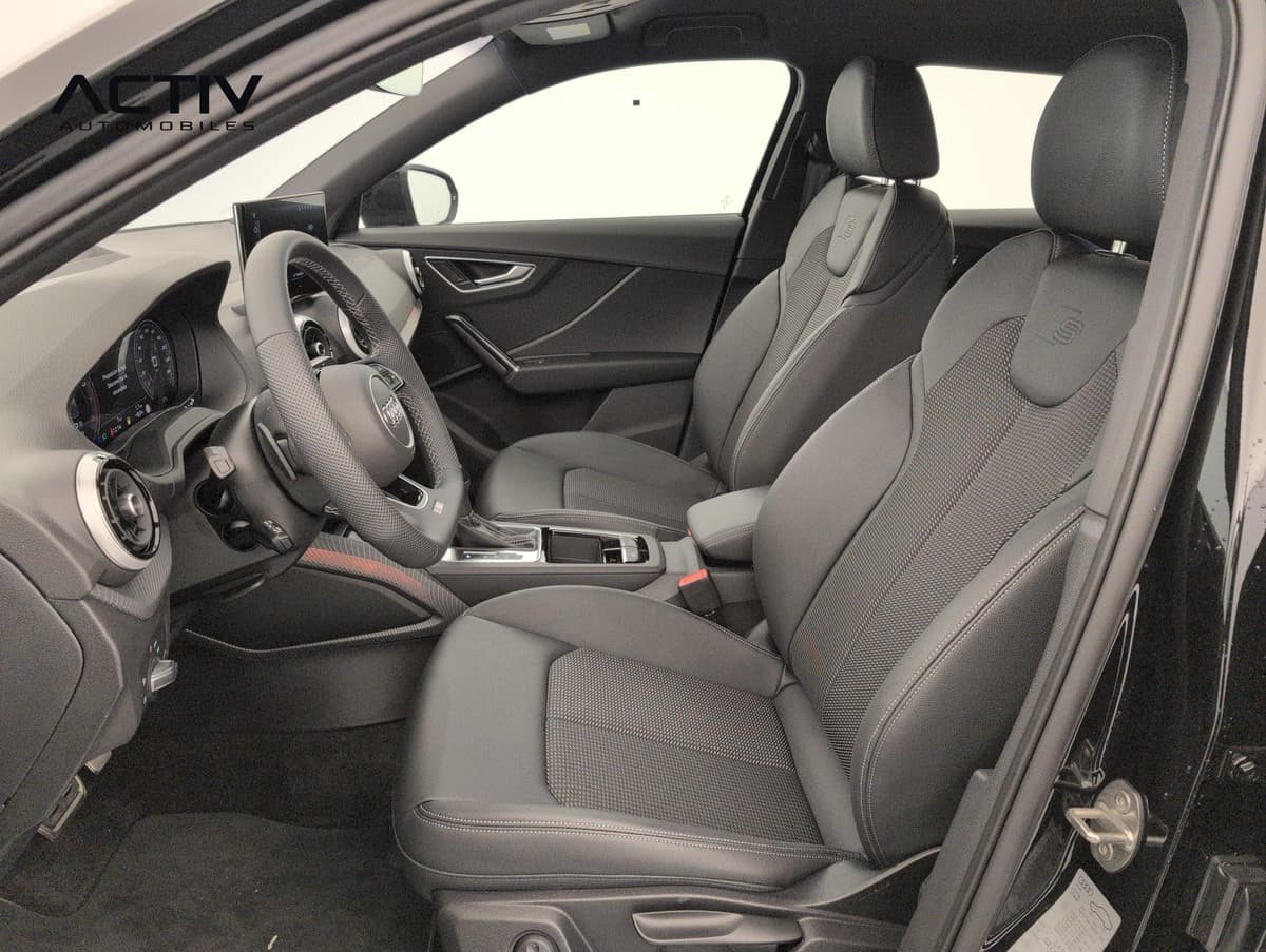 Audi Q2 : sièges avant sport noirs avec volant et levier de vitesses vus par la portière