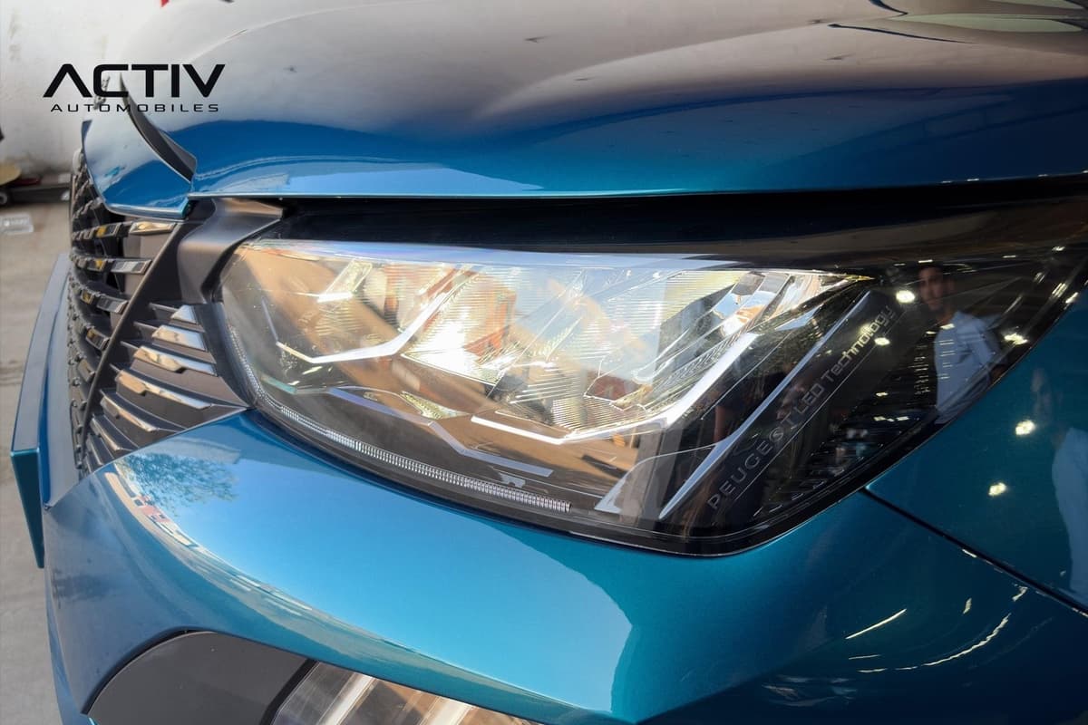 Peugeot 2008 : projecteur avant à LED vu de près, avec calandre et capot bleus
