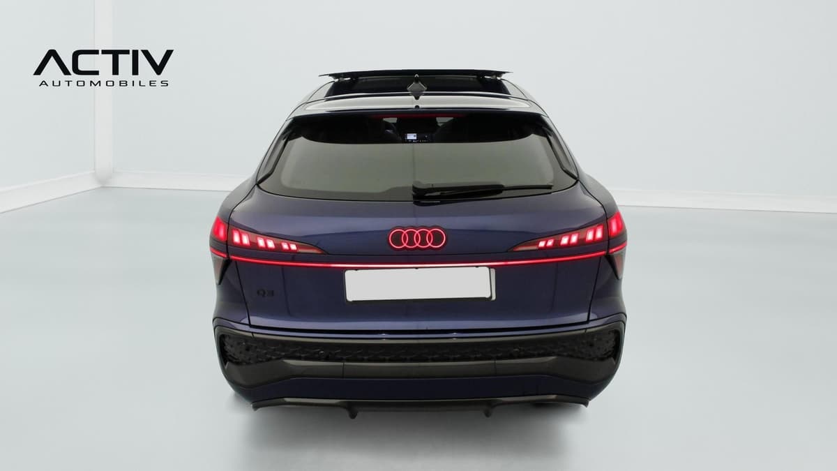 Audi Q3 Sportback Hybride : face arrière avec feux à LED allumés, anneaux illuminés et bouclier sombre