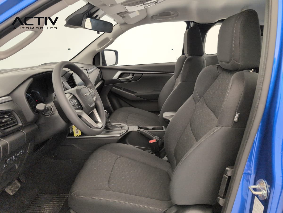 Isuzu D-MAX : sièges avant en tissu gris foncé et volant, vus par la portière ouverte