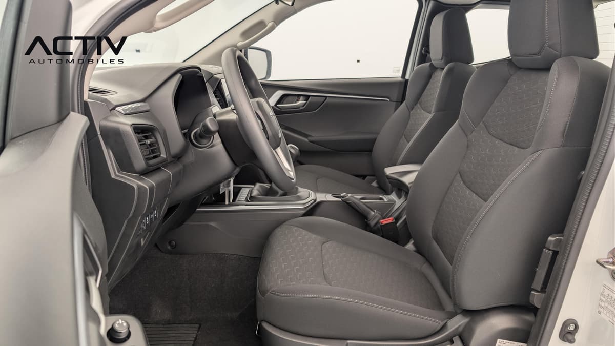 Isuzu D-MAX : habitacle avant avec sièges en tissu noir, volant et levier de vitesses