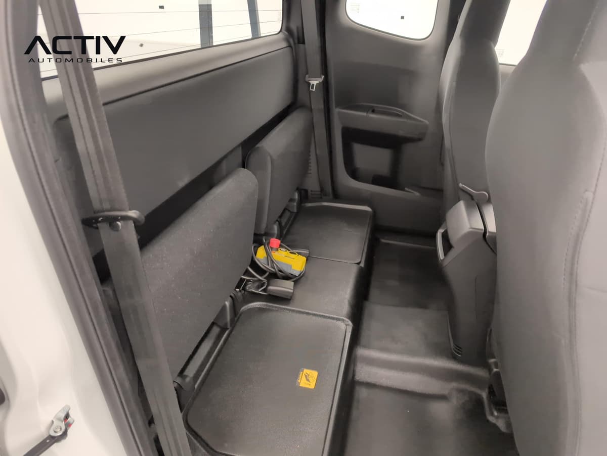 Isuzu D-MAX : sièges arrière relevables en tissu sombre dans la cabine, vus par la portière