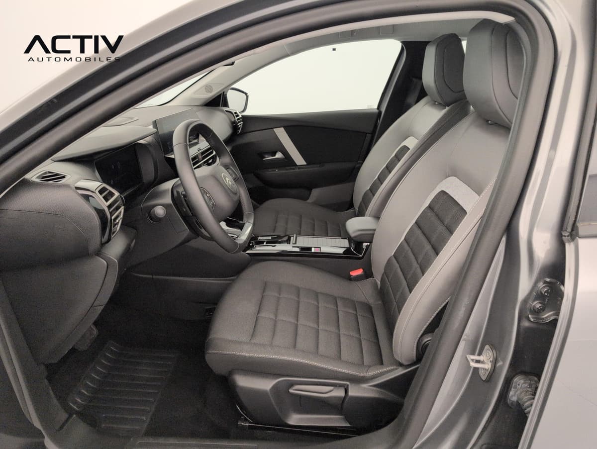 Citroën C4 : sièges avant en tissu gris et noir vus par la portière conducteur ouverte