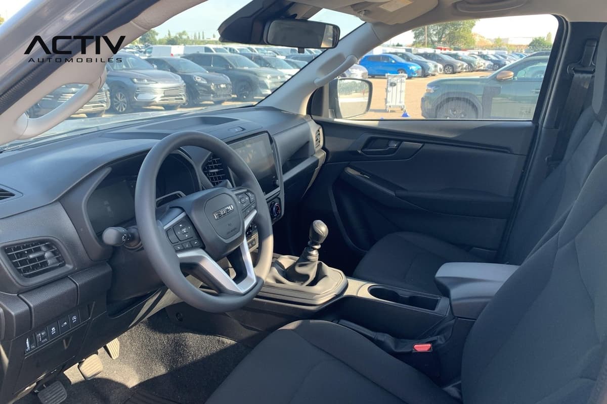 Isuzu D-MAX : habitacle avant avec volant, levier de vitesses manuel et sièges en tissu noir