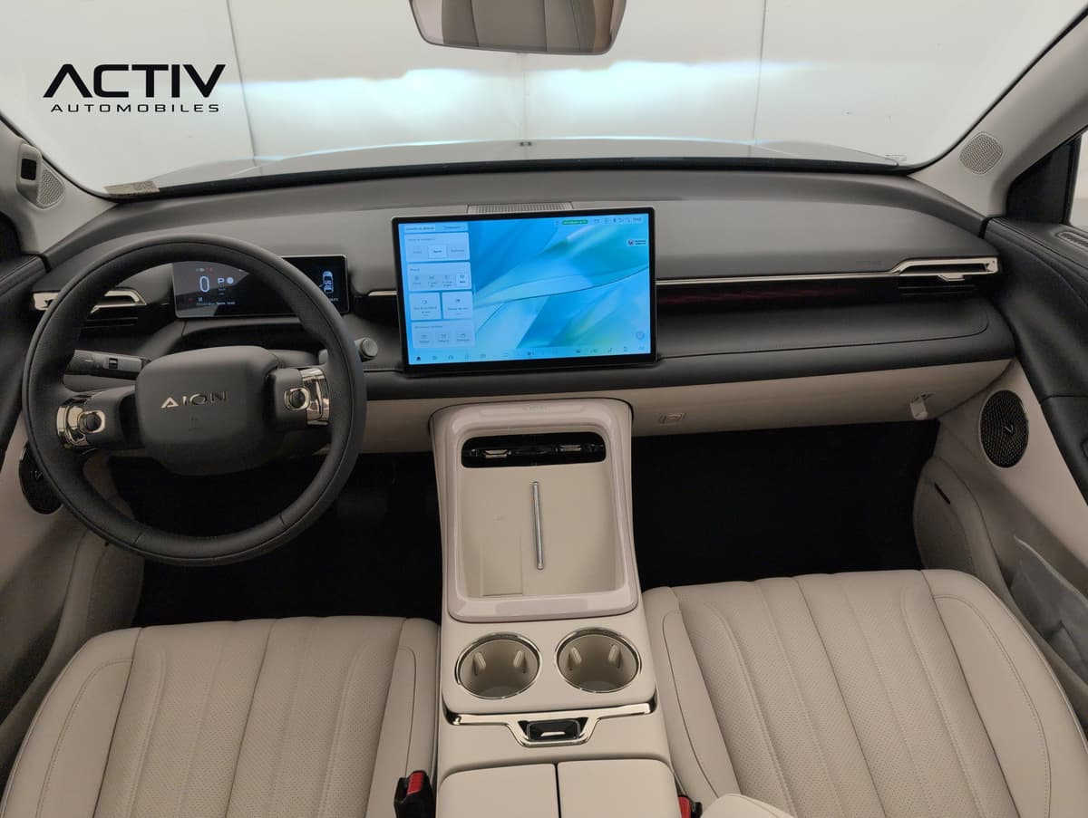 Aion V : planche de bord avec grand écran tactile, volant et console centrale beige