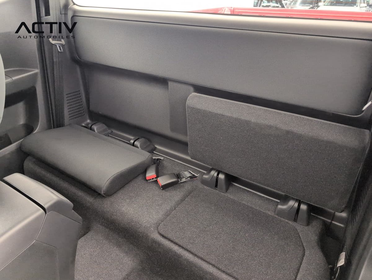 Isuzu D-MAX : sièges arrière rabattables en tissu noir de la cabine, vus depuis l'avant