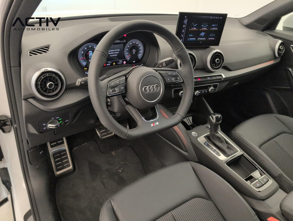 Audi Q2 : poste de conduite avec volant sport, écran tactile et pédalier métallique
