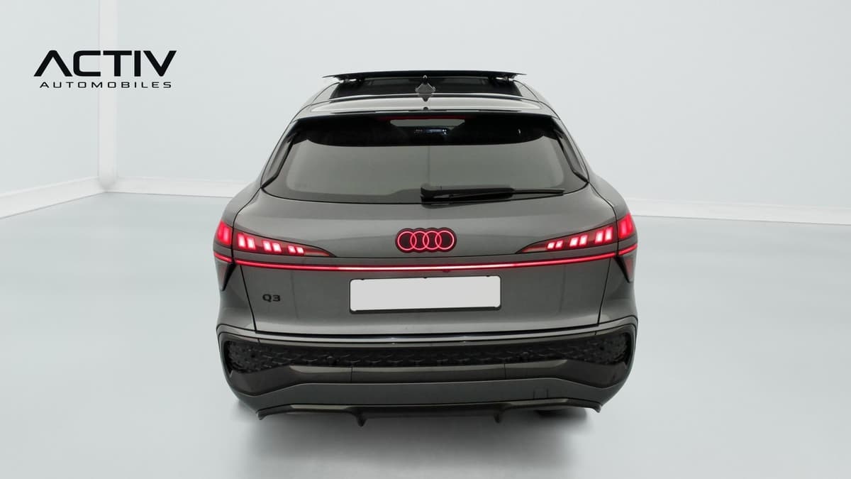 Audi Q3 Sportback Hybride : face arrière avec feux allumés, anneaux lumineux et bandeau lumineux rouge