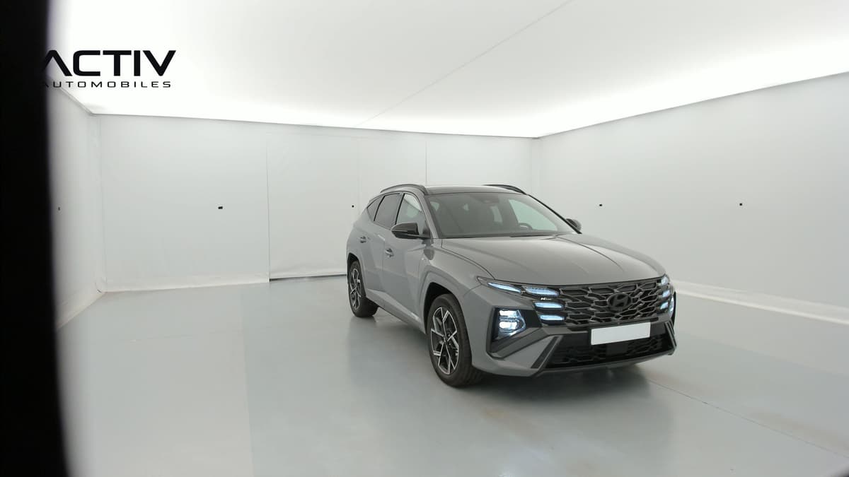 Hyundai Tucson : SUV gris vu de l'avant trois quarts droit, feux LED allumés et jantes alliage