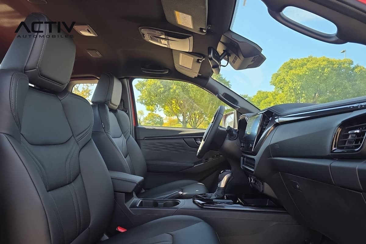 Isuzu D-MAX : habitacle avant vu côté passager avec sièges noirs, console et écran