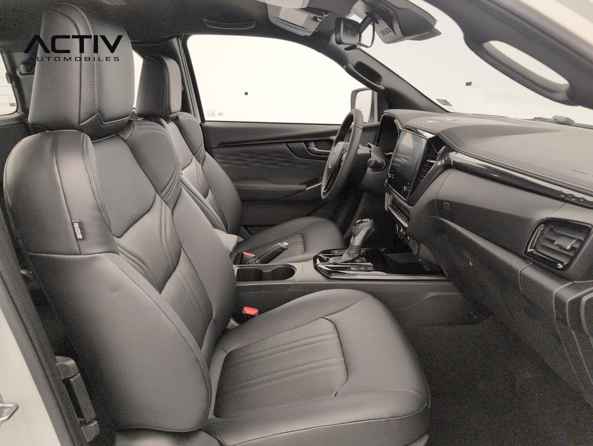 Isuzu D-MAX : sièges avant en cuir noir, console centrale et planche de bord vus côté passager