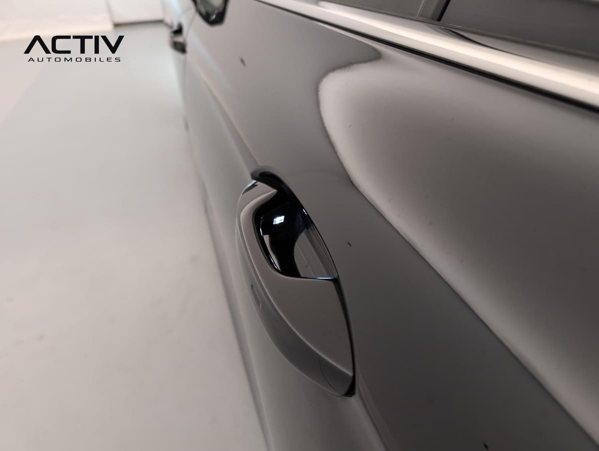 Volkswagen Passat : poignée de porte noire affleurante sur une portière noire brillante