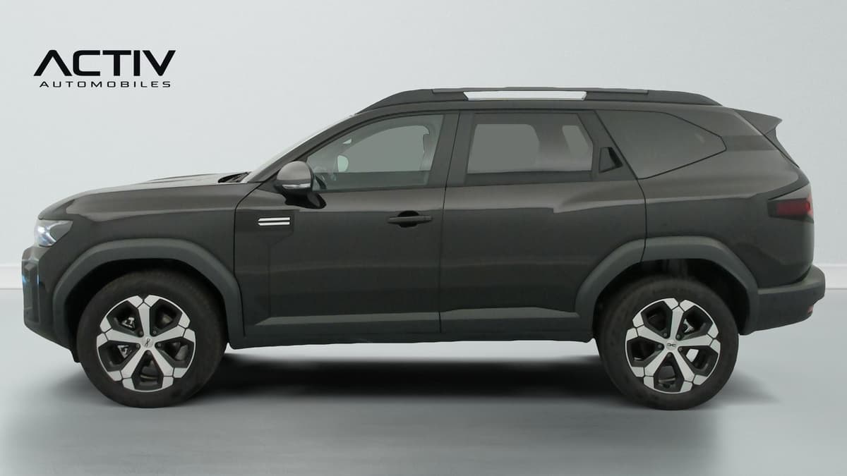 Dacia Bigster Hybrid : profil gauche du SUV avec barres de toit et jantes alliage bicolores