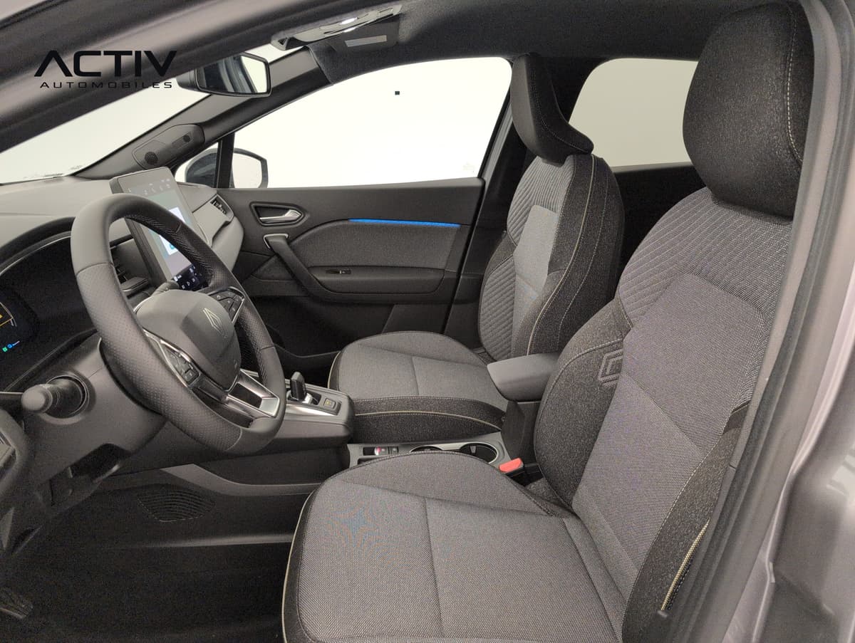 Renault Captur : sièges avant en tissu gris, volant et écran central vus par la portière