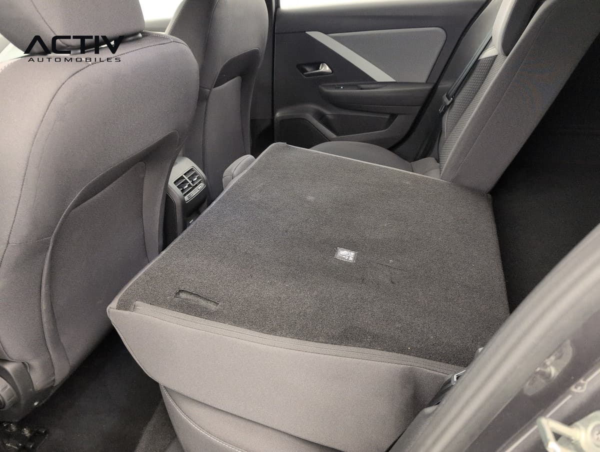 Opel Astra : banquette arrière rabattue en partie, dossier moquetté à plat, vue par la portière