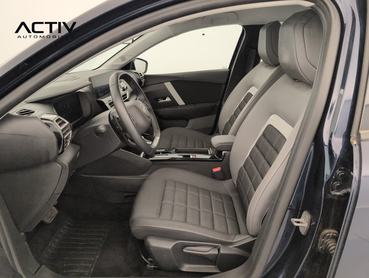 Citroën C4 : sièges avant en tissu gris et noir vus par la portière passager ouverte