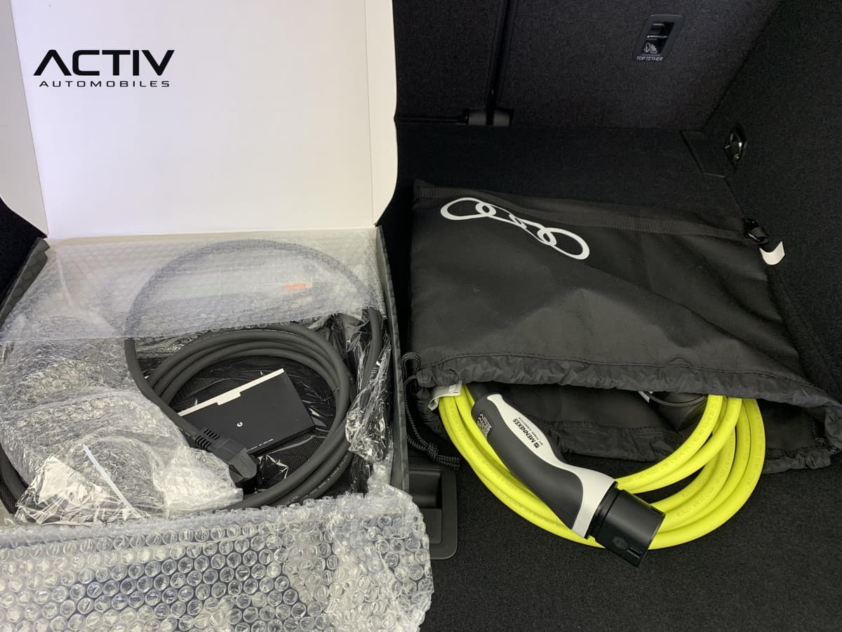 Audi Q3 Sportback Hybride : câbles de recharge, l'un dans sa boîte et l'autre jaune dans une housse noire