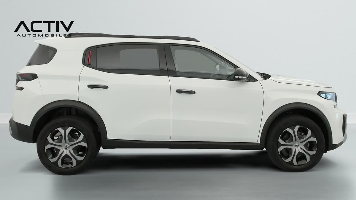 Citroën C3 Aircross : profil droit du SUV blanc avec barres de toit, jantes et poignées noires