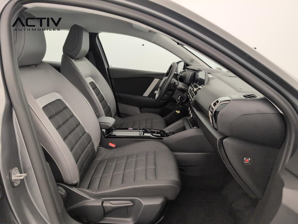 Citroën C4 : sièges avant en tissu noir et gris vus depuis la portière passager ouverte