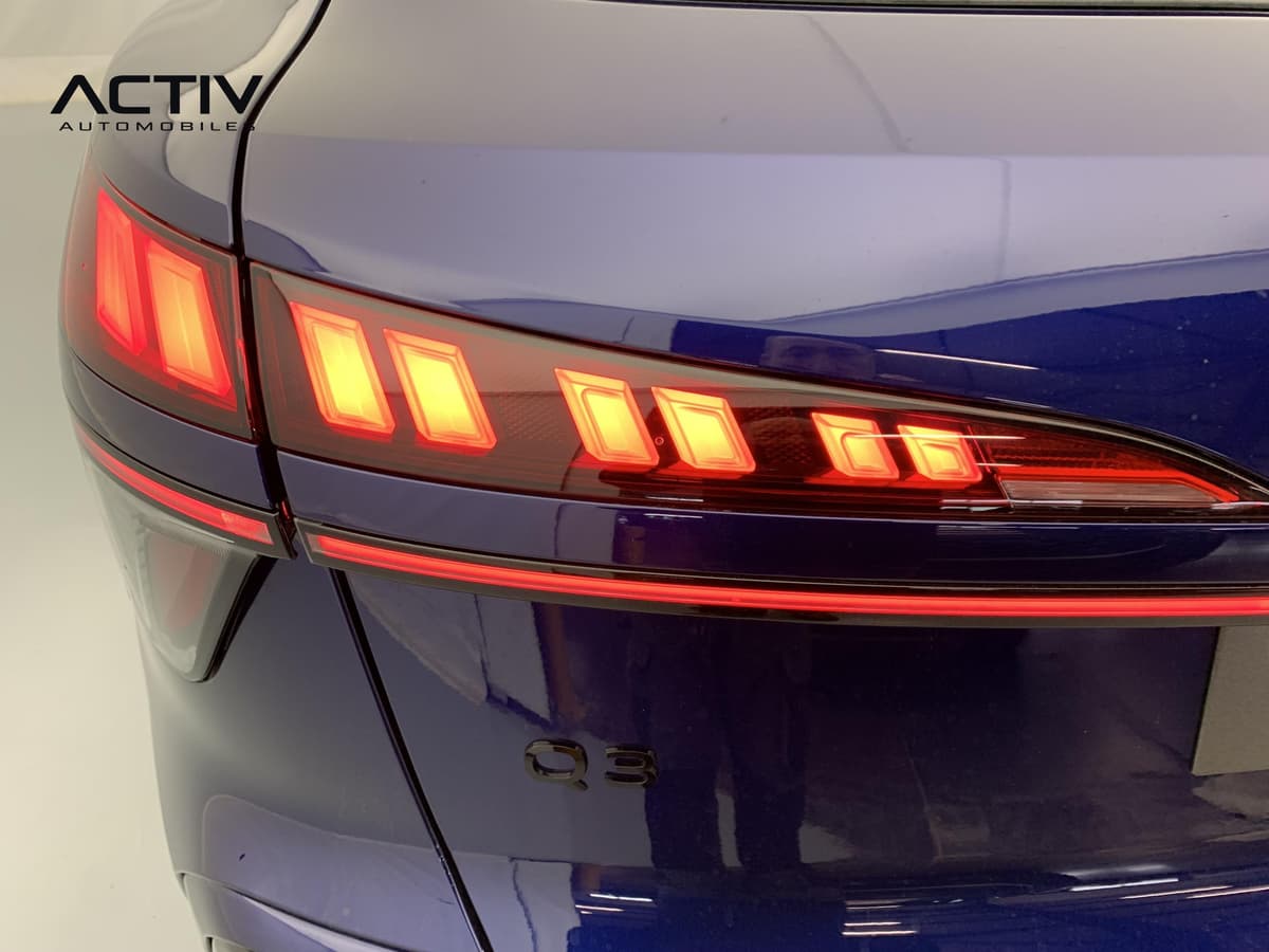 Audi Q3 Sportback Hybride : feu arrière allumé à segments lumineux et bandeau rouge sur le hayon