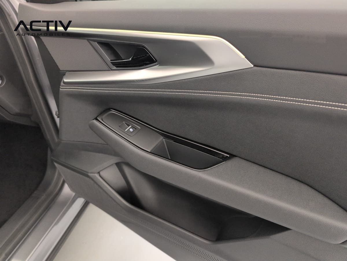 Renault Austral : panneau de porte sombre avec commande de lève-vitre et poignée