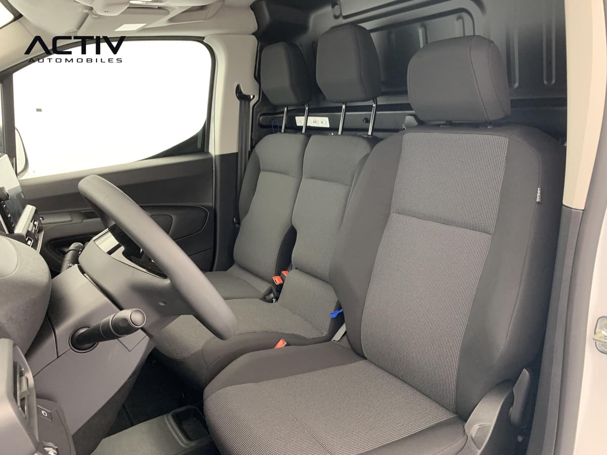 Peugeot Partner Fourgon : sièges avant en tissu gris et noir avec appuis-tête, vus depuis la porte conducteur