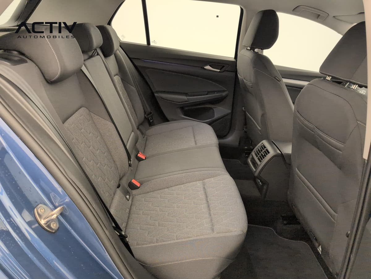 Volkswagen Golf 8 : banquette arrière en tissu gris foncé vue par la portière arrière ouverte
