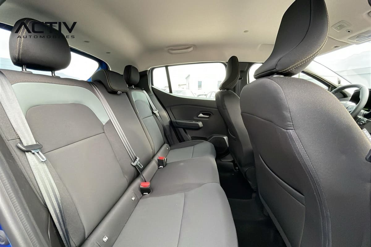 Dacia Sandero Gpl : banquette arrière en tissu noir et gris avec ceintures, vue depuis la portière