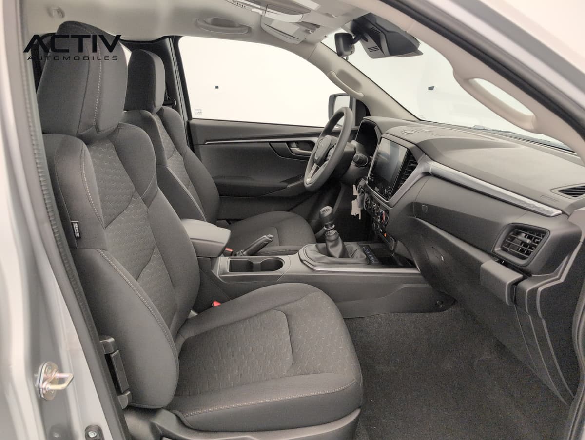 Isuzu D-MAX : habitacle avant côté passager avec sièges en tissu noir et levier de vitesses manuel