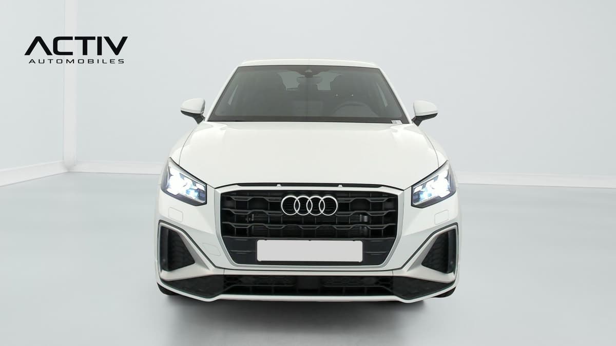 Audi Q2 : face avant blanche avec calandre noire et phares allumés