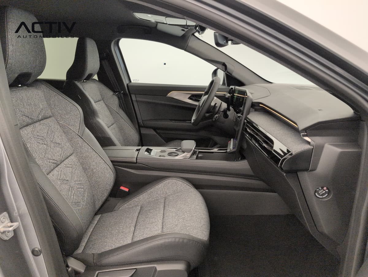 Renault Austral : siège passager avant en tissu gris avec motif embossé, vu par la portière ouverte