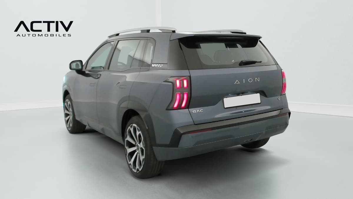Aion V : SUV vu de l'arrière trois quarts gauche avec barres de toit et jantes bicolores