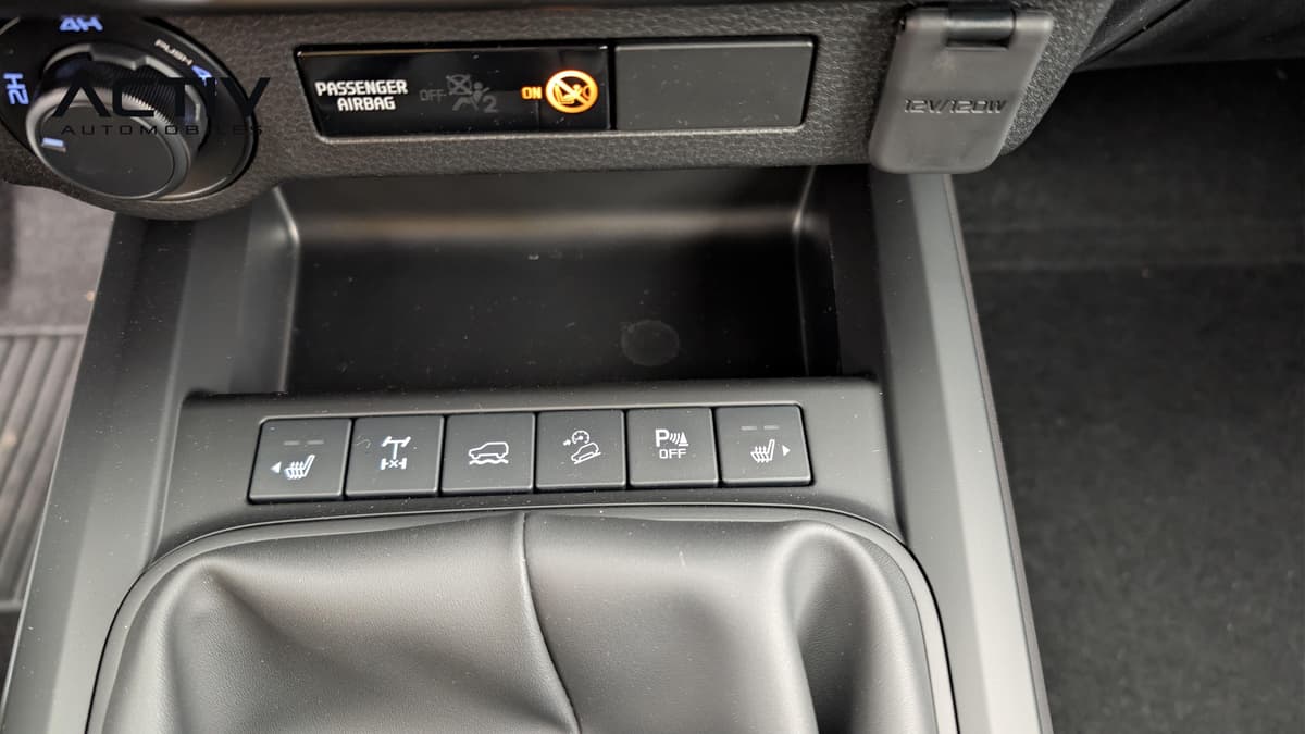 Isuzu D-MAX : console centrale avec boutons de sièges chauffants, prise 12 V et soufflet de levier