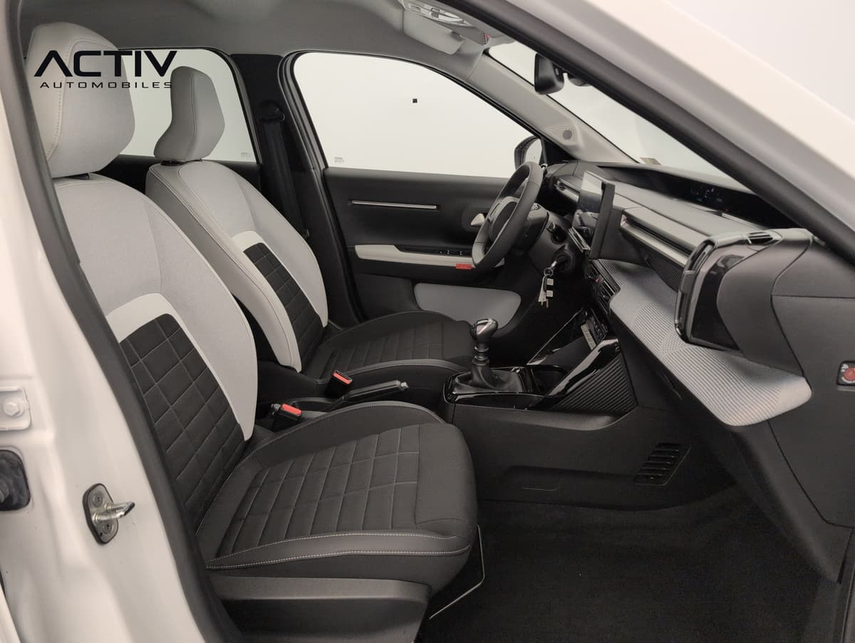 Citroën C3 : sièges avant en tissu noir et gris clair, planche de bord et levier de vitesses