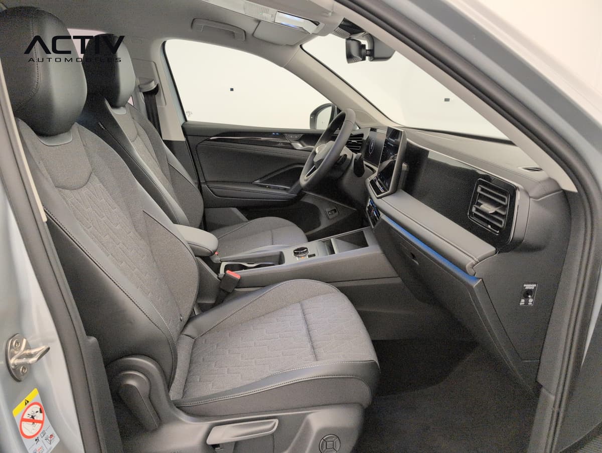 Volkswagen Tiguan : habitacle avant côté passager avec sièges en tissu gris et console centrale