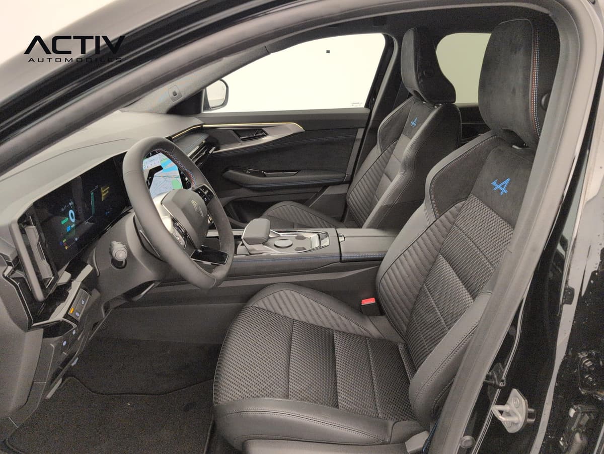 Renault Austral : sièges avant noirs avec logo bleu, volant et console centrale vus par la portière