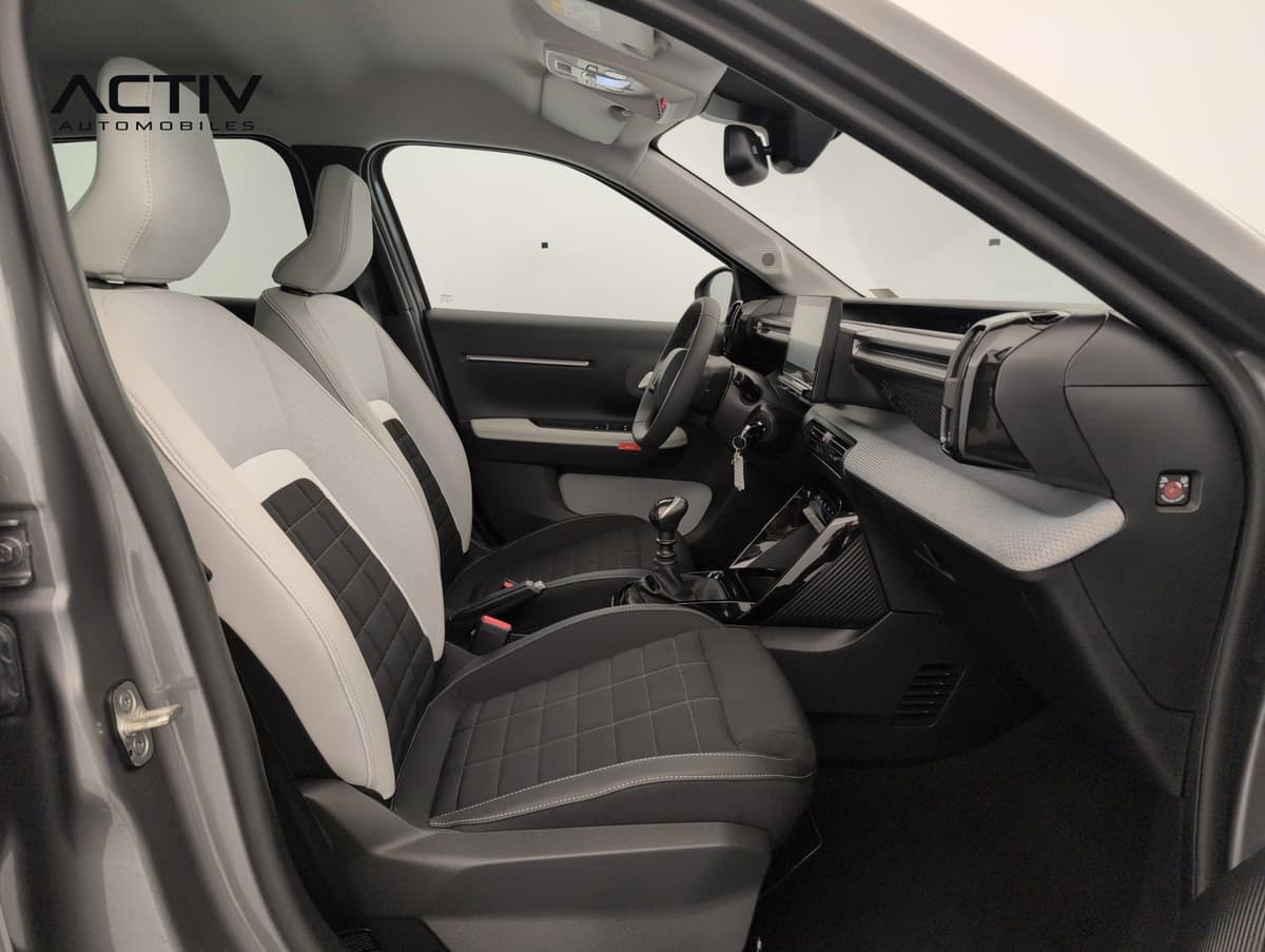Citroën C3 : habitacle avant côté passager avec sièges bicolores et levier de vitesses manuel