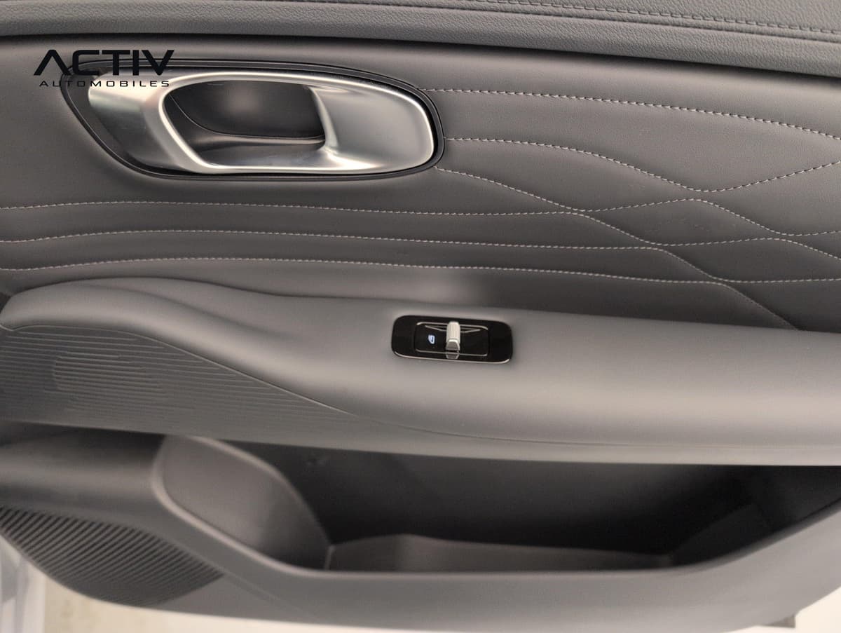 Geely Starray : panneau de porte gris avec poignée, surpiqûres et commande de vitre