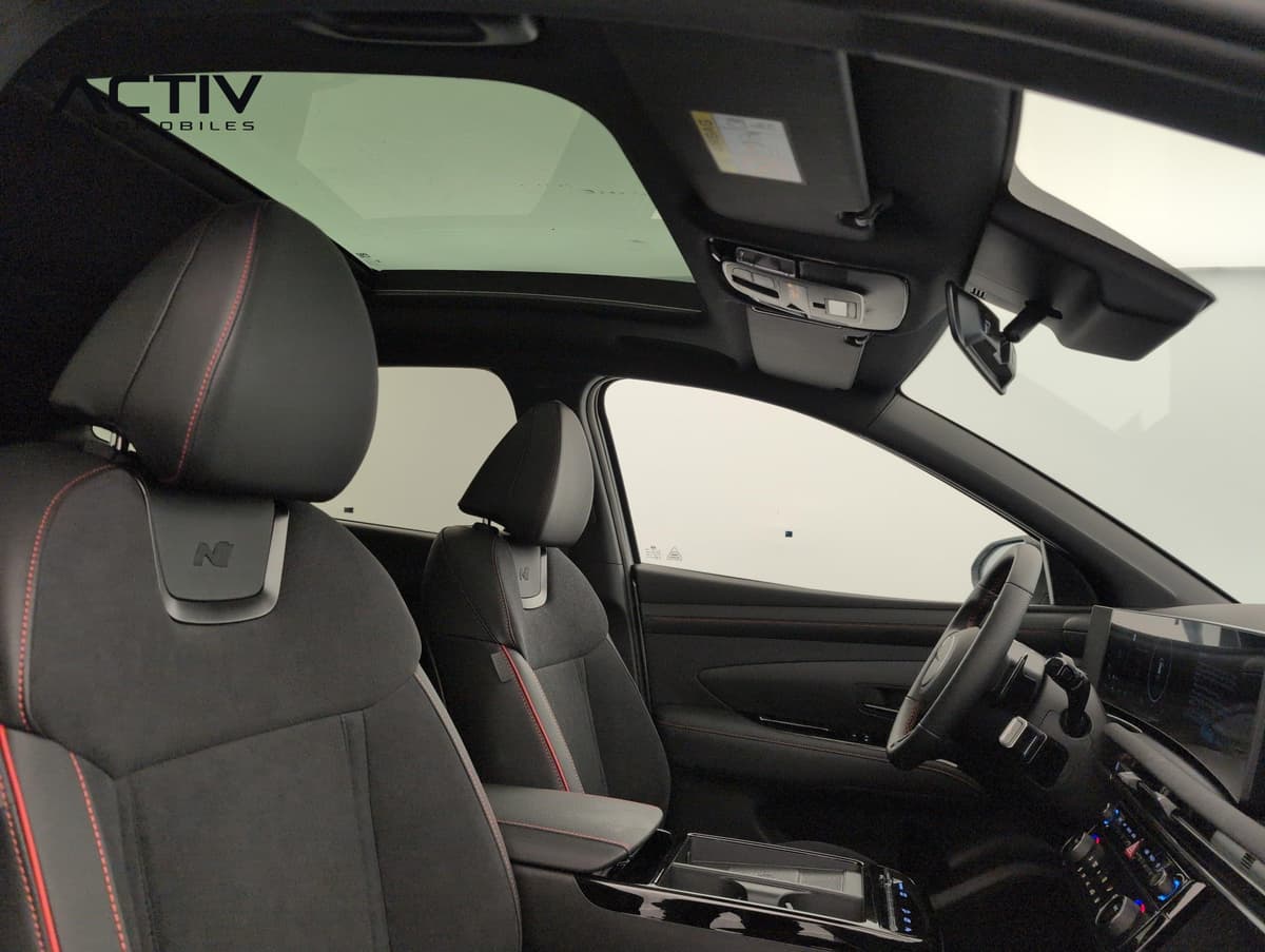 Hyundai Tucson : sièges avant noirs surpiqués de rouge sous le toit ouvrant panoramique
