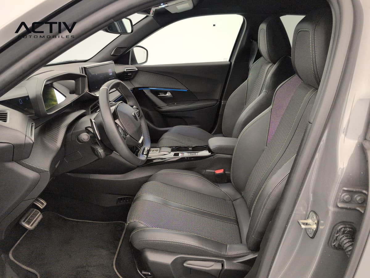 Peugeot 2008 : sièges avant en tissu noir et volant compact vus par la portière conducteur