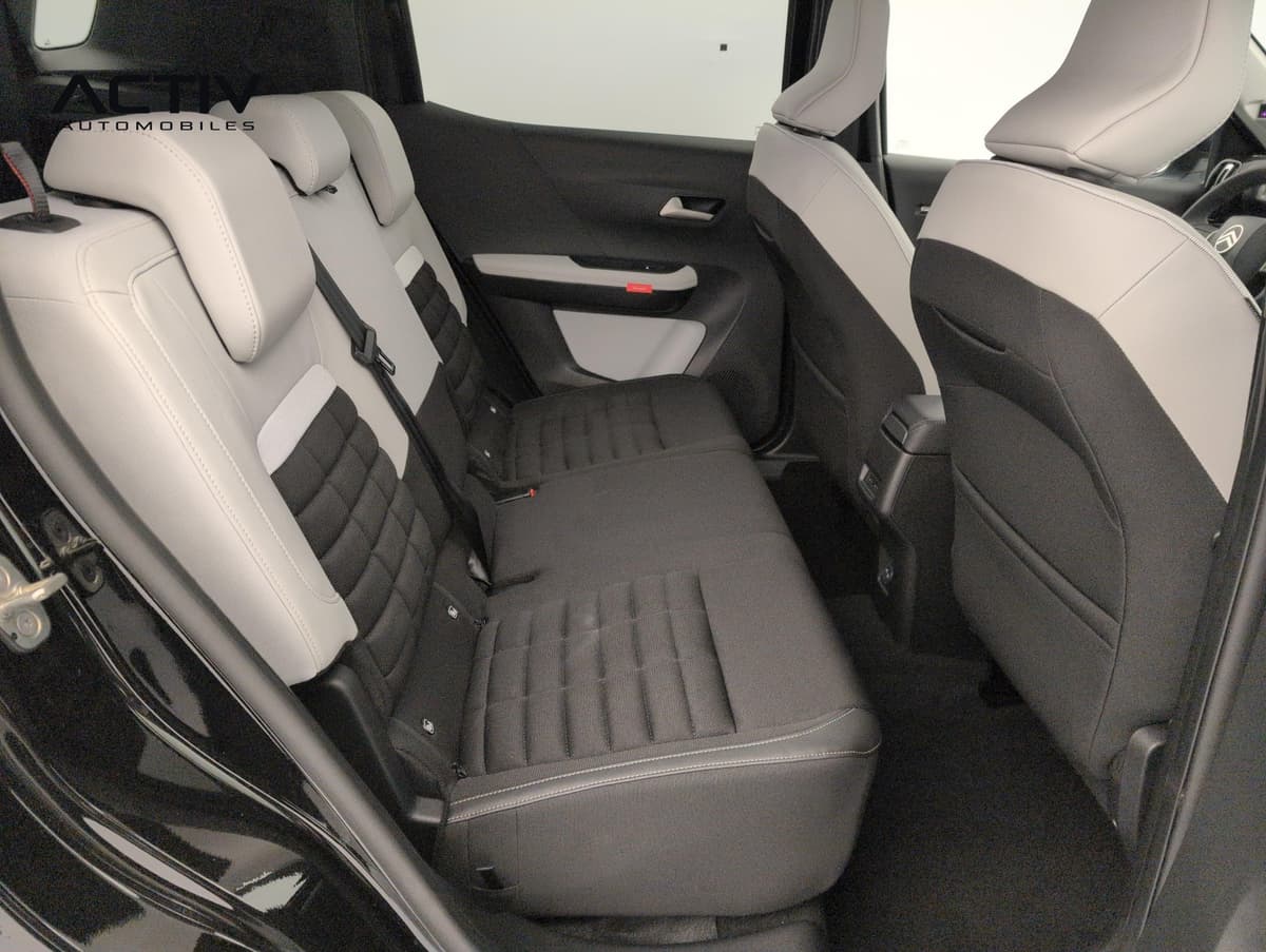Citroën C3 Aircross : banquette arrière en tissu noir et gris clair avec appuis-tête, vue par la portière