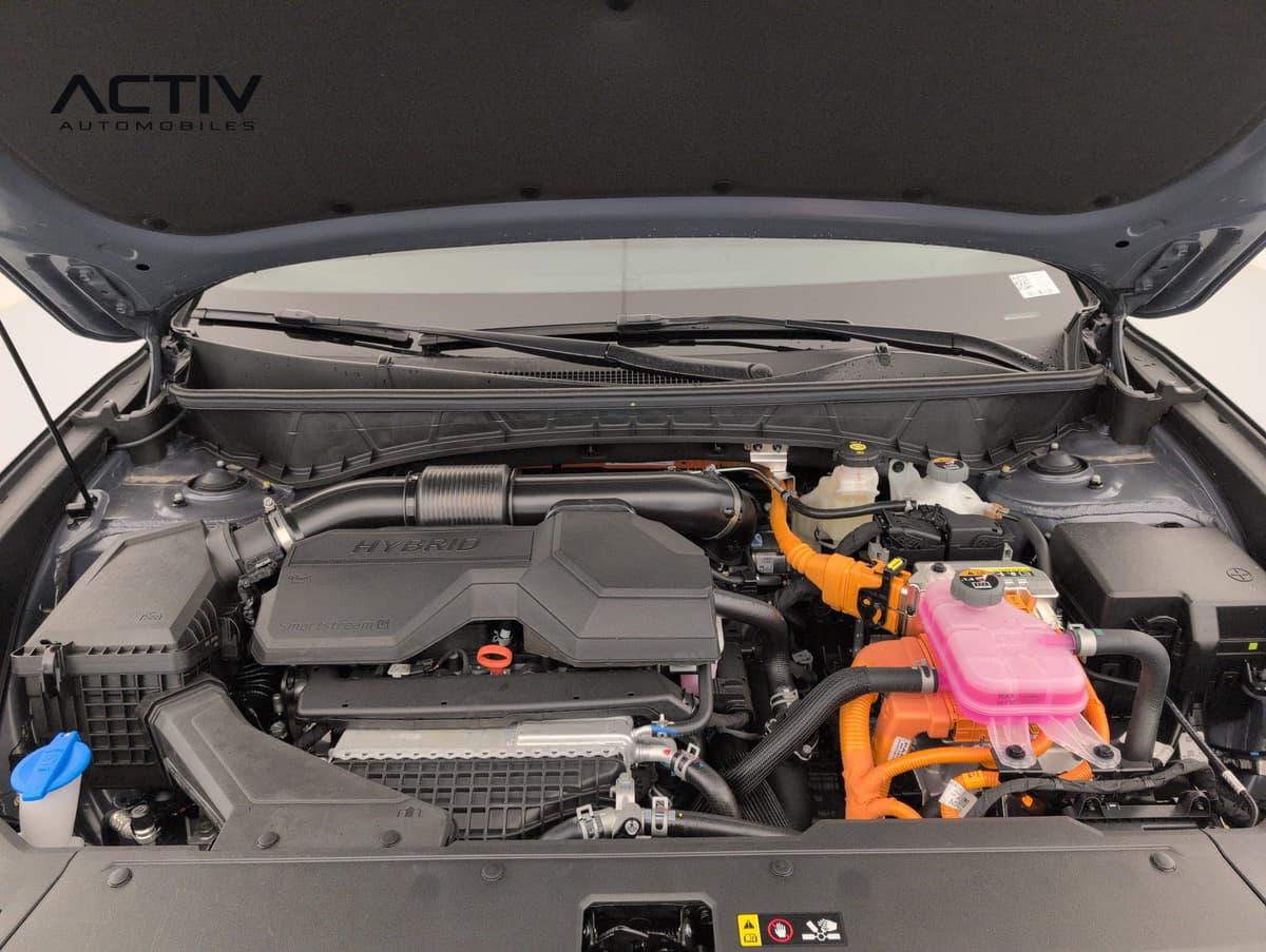 Hyundai Tucson : compartiment moteur hybride avec câbles orange et cache moteur noir