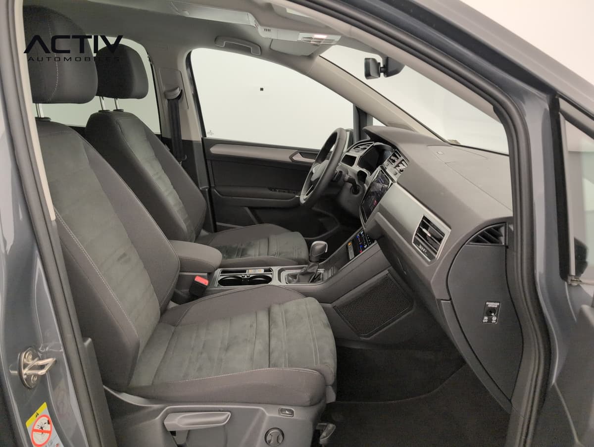 Volkswagen Touran : habitacle avant côté passager avec sièges en tissu sombre et console centrale